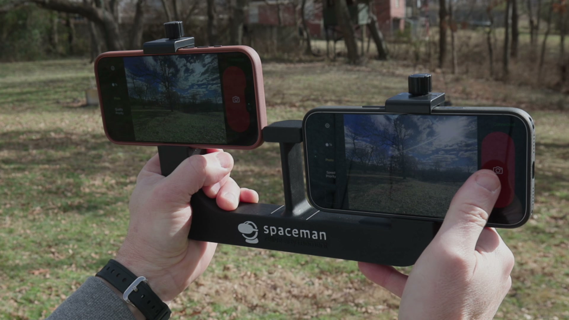 Hands holding the Spaceman rig with two iPhones mounted side by side, both recording the same scene
